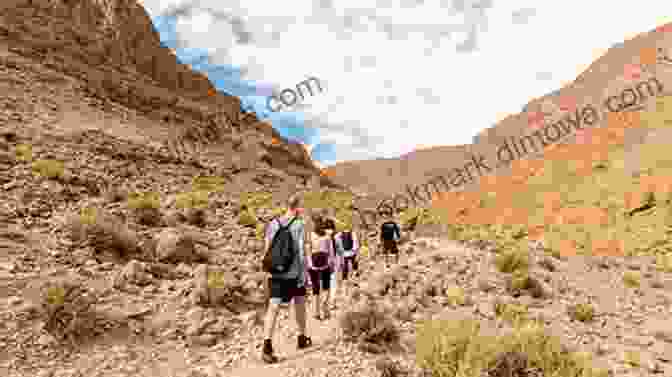 Trekkers Hiking Through The Atlas Mountains, Surrounded By Towering Peaks And Lush Greenery. The Mountains Look On Marrakech: A Trek Along The Atlas Mountains